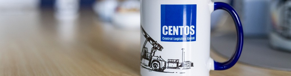 Bildmotiv mit einem Kaffeebecher mit centos-Logo auf einem Bürotisch